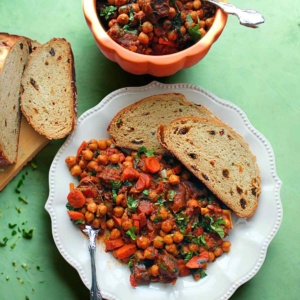 Moroccan Chickpea Goat Stew on a serving plate with crusty bread.