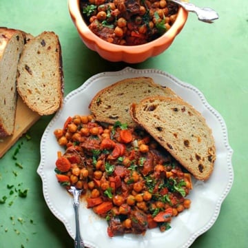 Moroccan Chickpea Goat Stew on a serving plate with crusty bread.