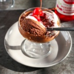 Coconut mousse with chocolate served in a glass cup.
