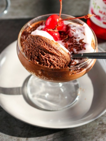 Coconut mousse with chocolate served in a glass cup.
