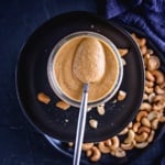 cashew pasta sauce in a mason jar scooped with a spoon.
