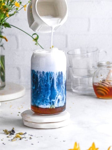A glass of butterfly pea tea latte.