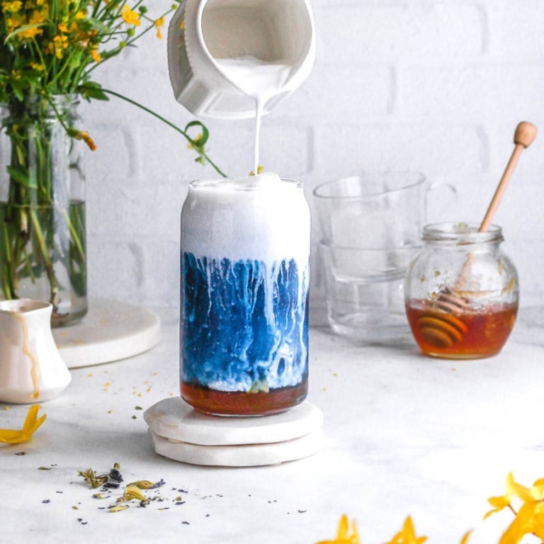 A glass of butterfly pea tea latte.