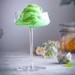 a glass filled with green ice cream.
