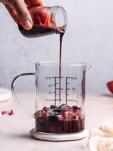 pouring pomegranate sauce in a jar