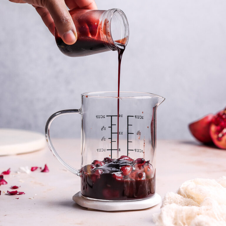 pouring pomegranate sauce in a jar