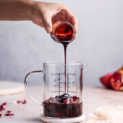 pouring pomegranate sauce in a jar
