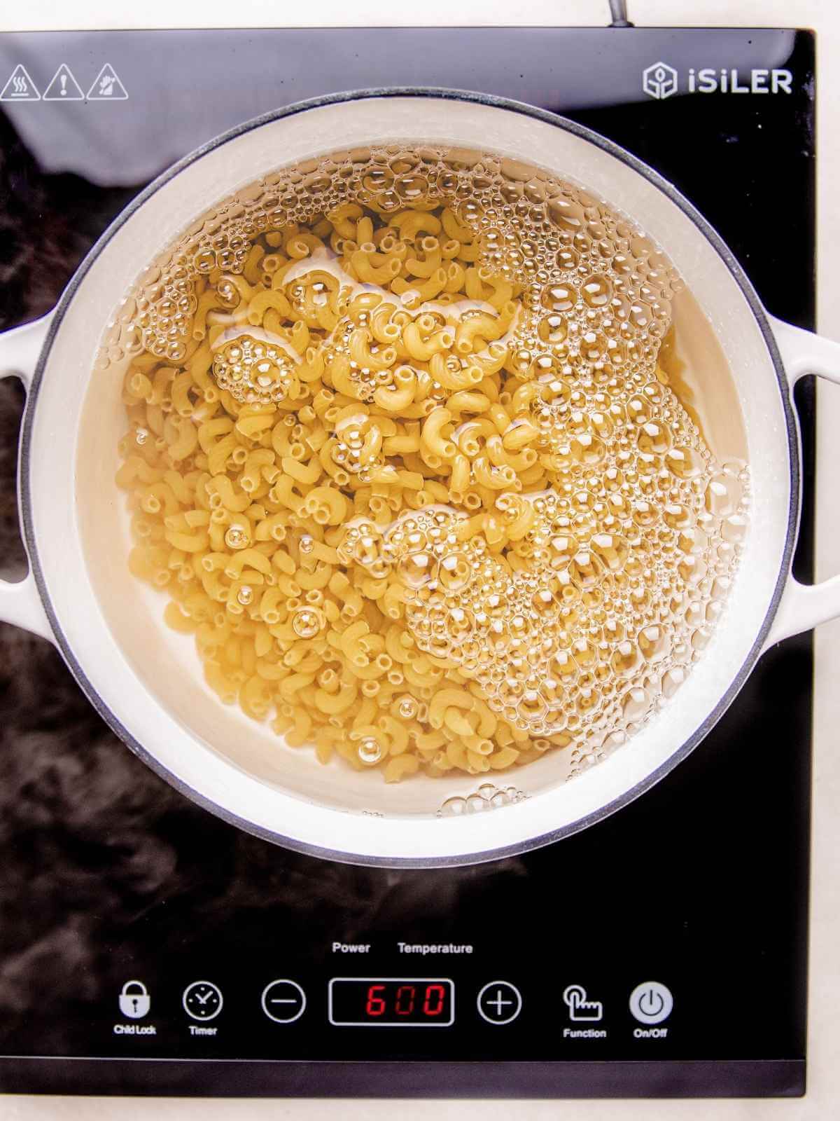 Cooking pasta according to package instructions.