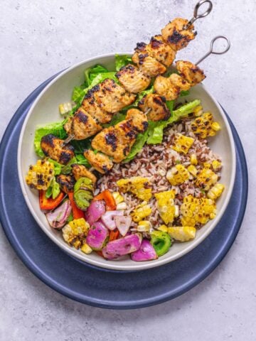 a bowl of Greek chicken skewers