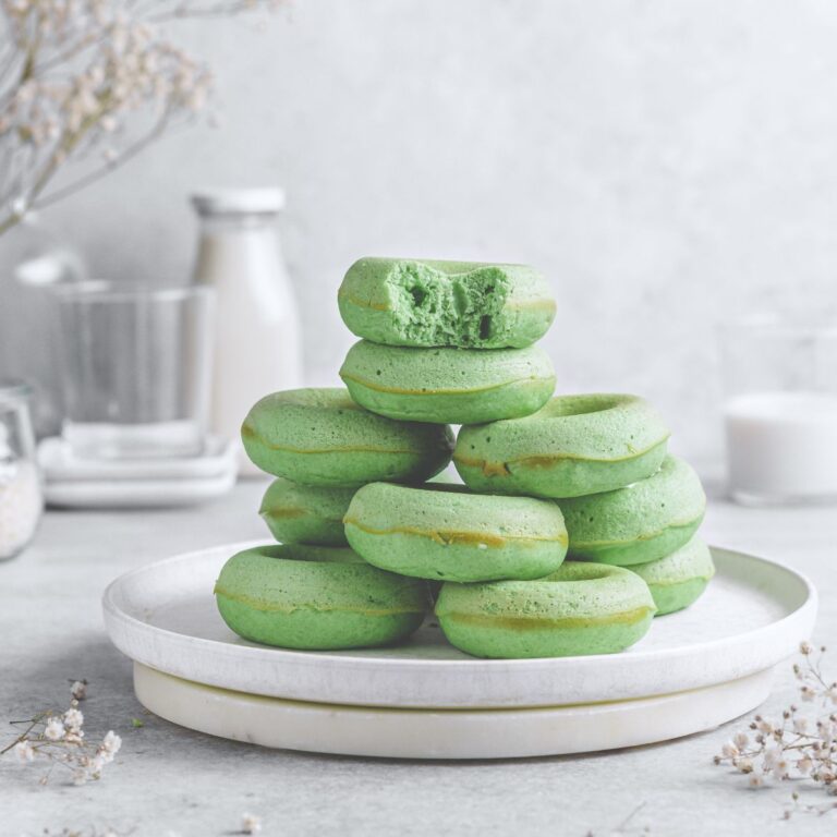 A Featured image of green donuts without glaze stacked up on a white plate