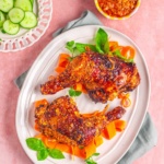 chicken peri peri on a white plate with vegetables.