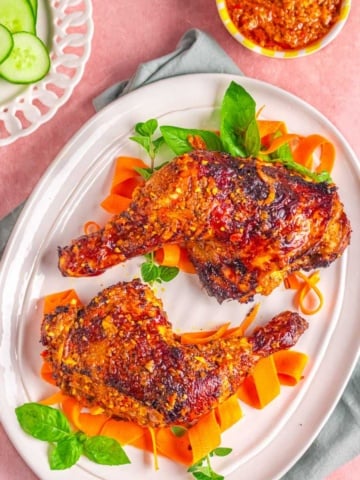 chicken peri peri on a white plate with vegetables.