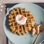 pecan pumpkin waffles on a green serving plate.