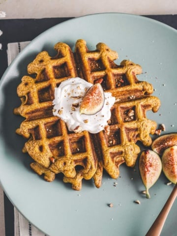 pecan pumpkin waffles on a green serving plate.