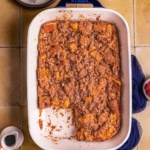 A baked French toast casserole with serving plates and fork.