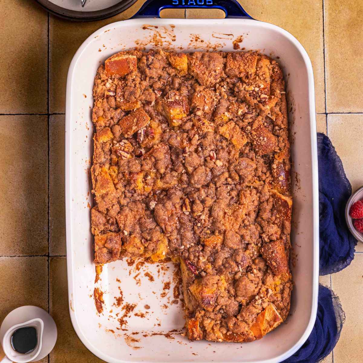 A baked French toast casserole with serving plates and fork.