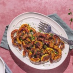 easy sautéed delicata squash on a plate with a green napkin and serving plates.