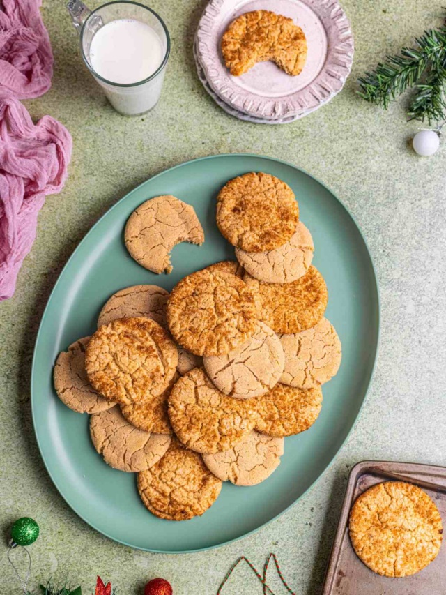 sugar cookies on a platter served with a glass of milk.