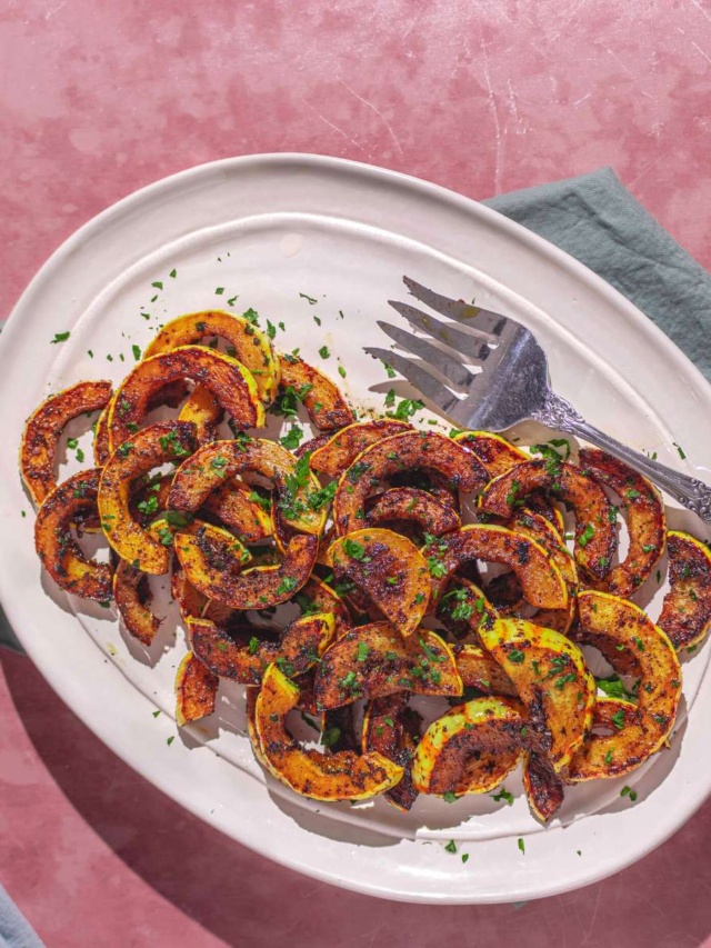 easy sautéed delicata squash on a plate with a green napkin and serving plates.