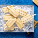 banana popsicles laid flat in an aluminum tray.