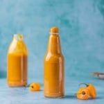 Sweet and Spicy Mango Habanero Sauce for wings in a bottle on a flat surface.
