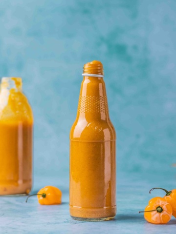 Sweet and Spicy Mango Habanero Sauce for wings in a bottle on a flat surface.