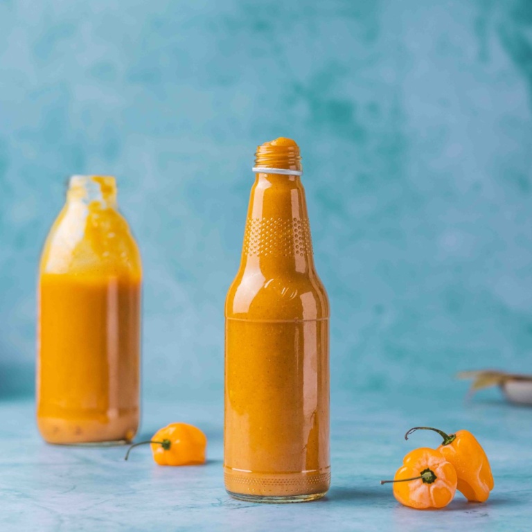 Sweet and Spicy Mango Habanero Sauce for wings in a bottle on a flat surface.