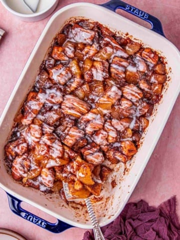 cinnamon roll with apple pie drizzled with creamy glaze.
