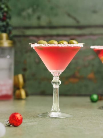 Christmas martini with salt frosted rim on a flat surface.