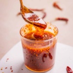 Hot honey sauce scooped in a spoon revealing texture and color.