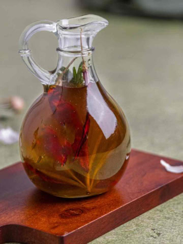 garlic infused olive oil in an oil jar on a flat surface.
