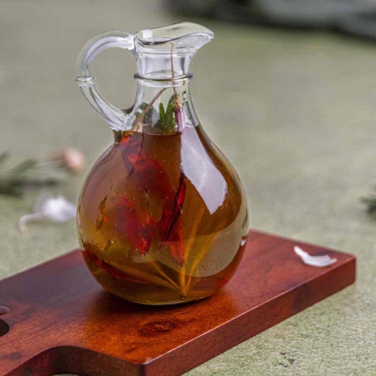 garlic infused olive oil in an oil jar on a flat surface.