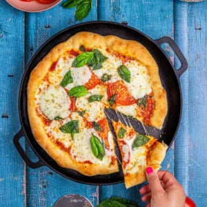 flatbread pizza margherita showing a slice of gooey melted cheese.