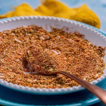 Homemade chicken taco seasoning in a plate, scooped to reveal the texture and colors.