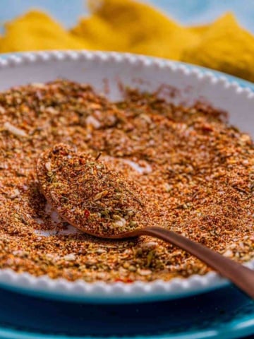 Homemade chicken taco seasoning in a plate, scooped to reveal the texture and colors.