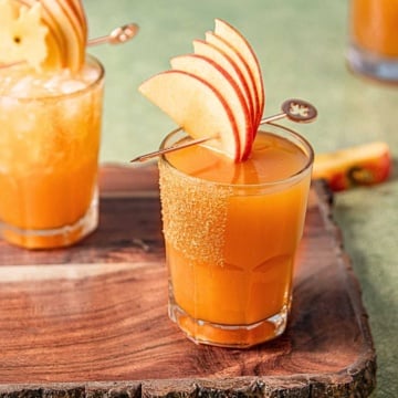 bourbon apple cider cocktail in a glass rimmed with cinnamon sugar.