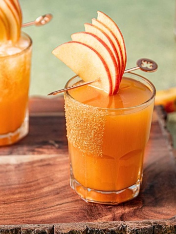 bourbon apple cider cocktail in a glass rimmed with cinnamon sugar.