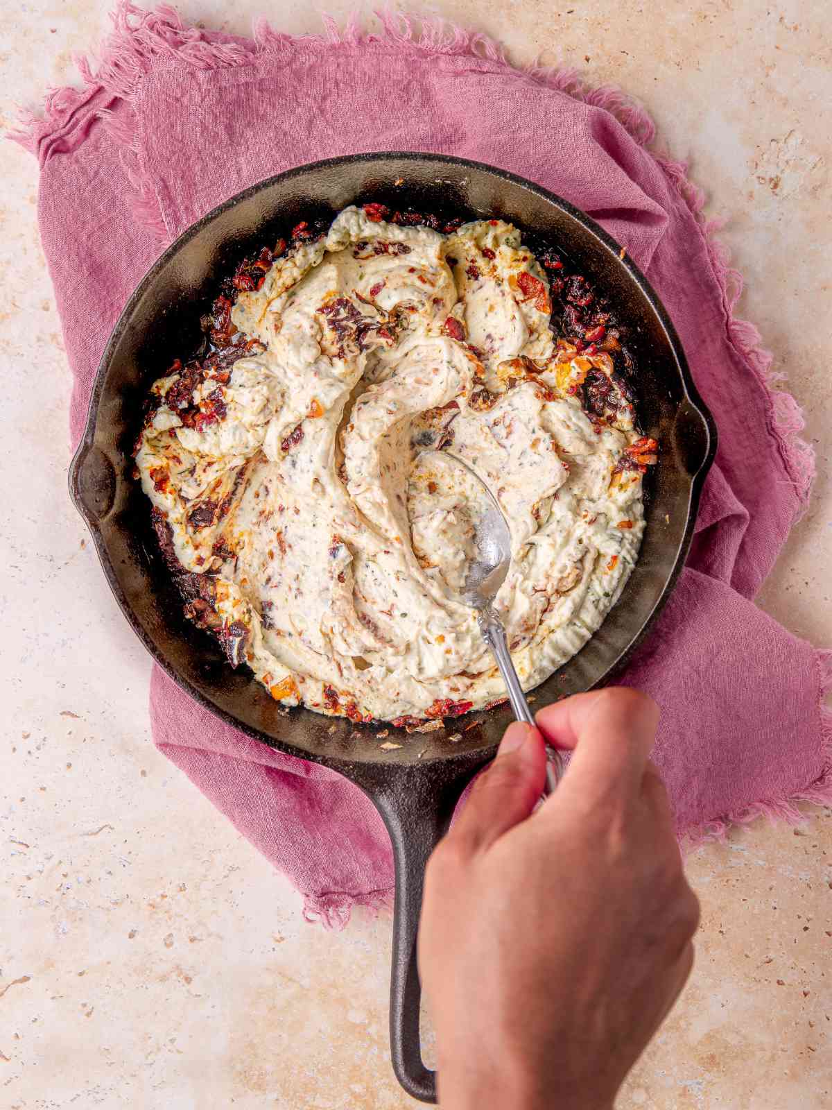 Combining the melted Boursin dip with the bacon, tomatoes mix.