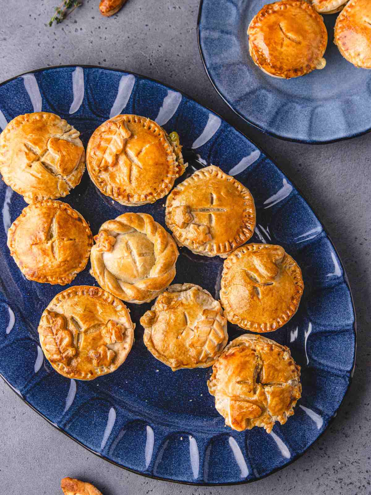 Muffin tin pot pie with decorated edges on a plate.