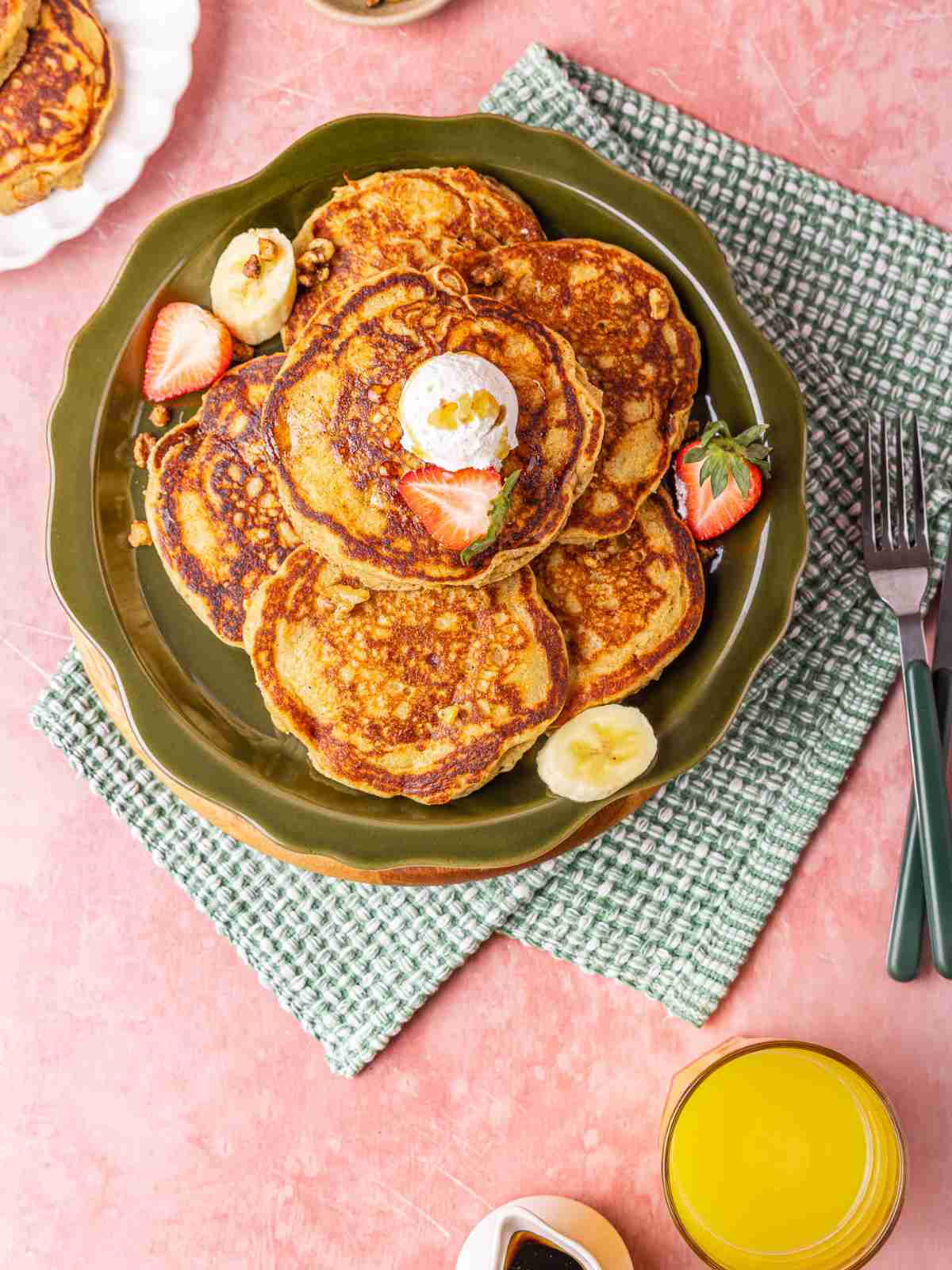 oat meal pancakes topped with whipped cream and bananas.