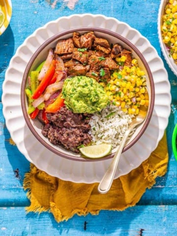 Steak and rice bowl on a flat surface.