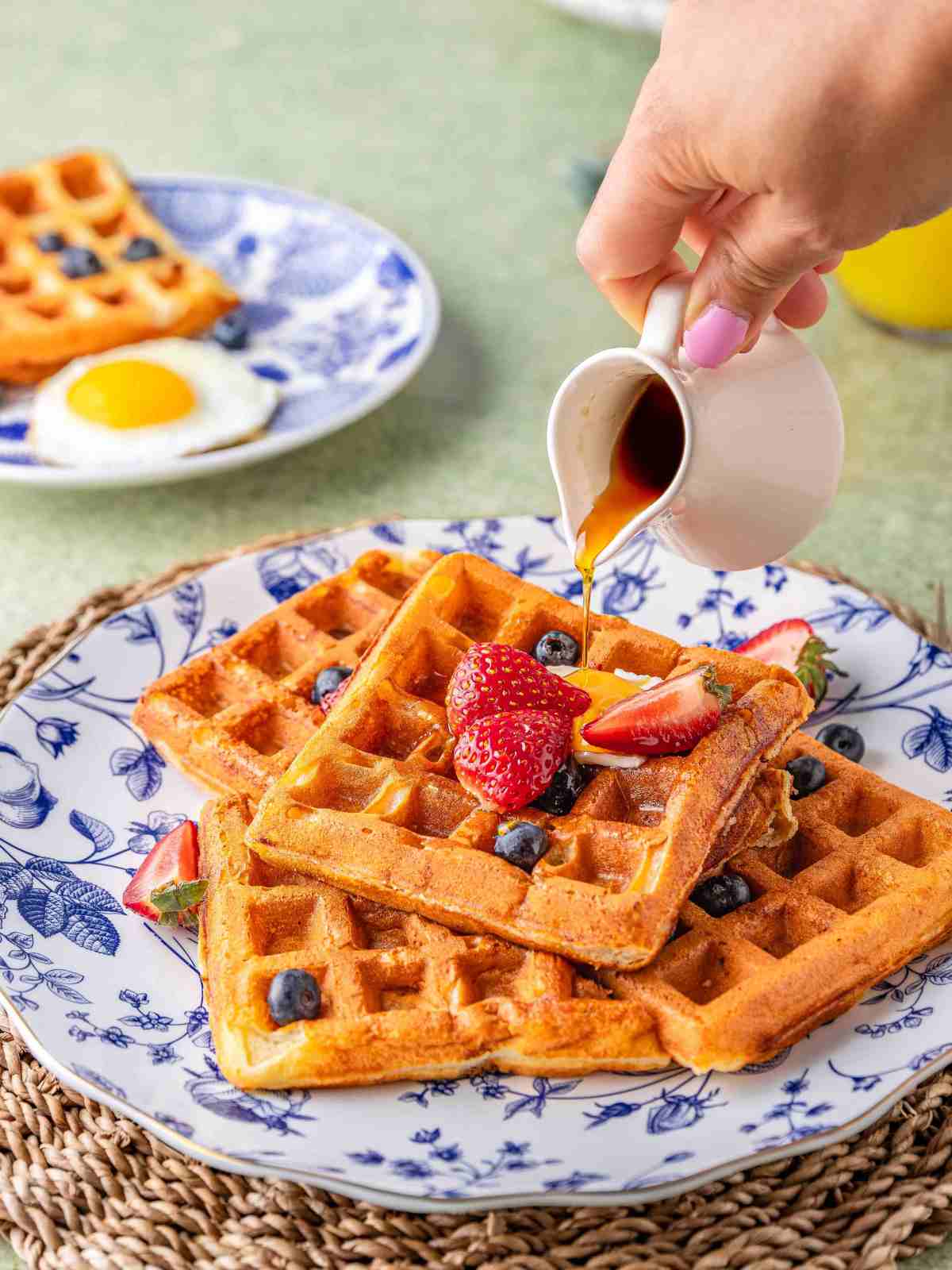 Pouring syrup over waffles.