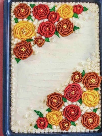 apple pumpkin sheet cake with maple frosting on a flat surface.
