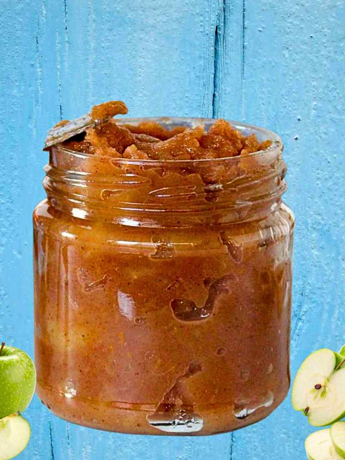 Apple sauce in a small jar with apples.