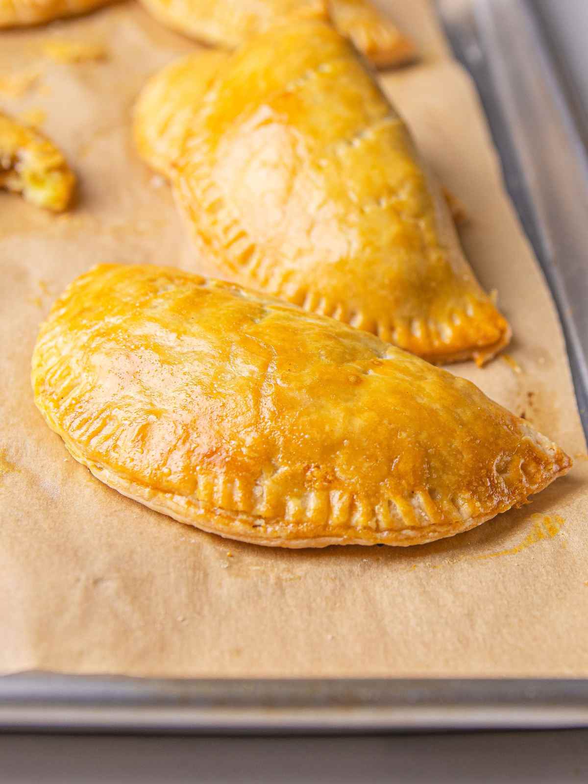 Hand pie with ground beef veggie filling on a sheet pan.