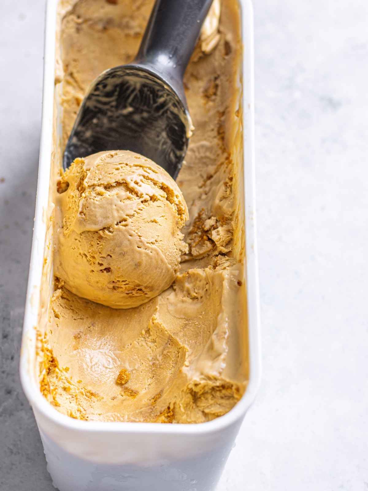 Scooping ice cream with biscoff butter and cookies.