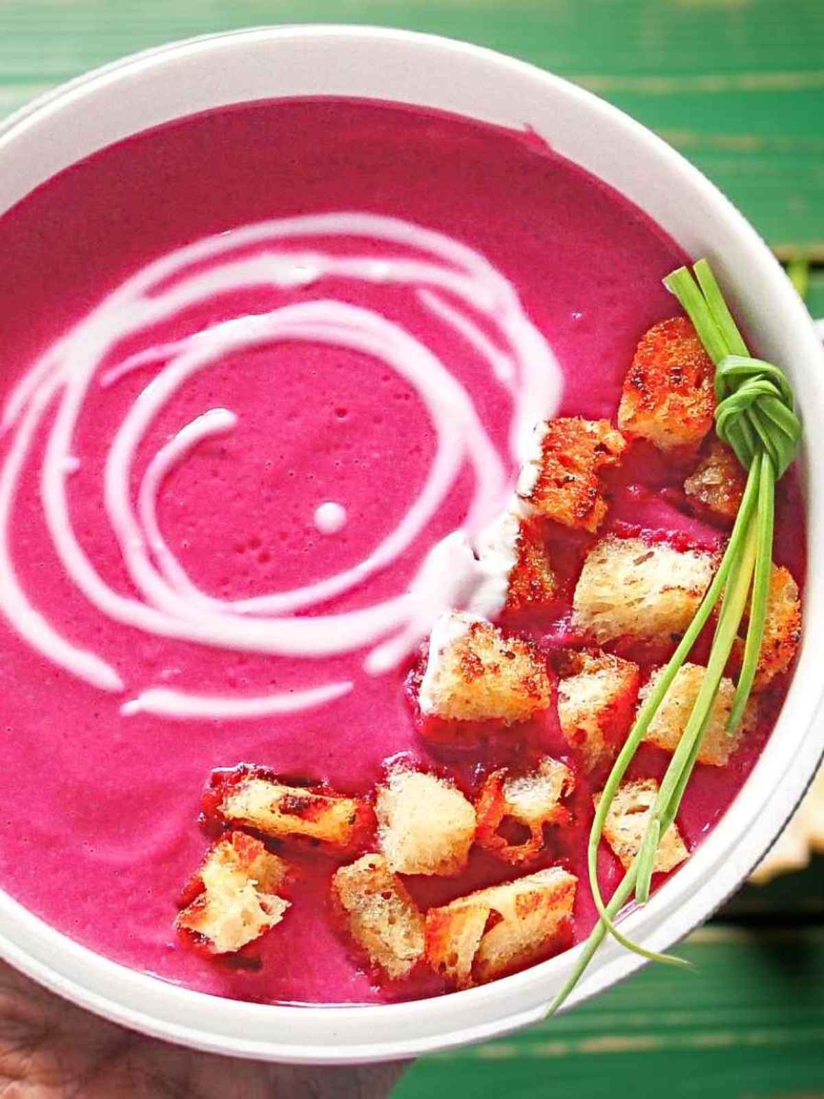 Roasted cauliflower soup with leeks in a bowl garnished with croutons.