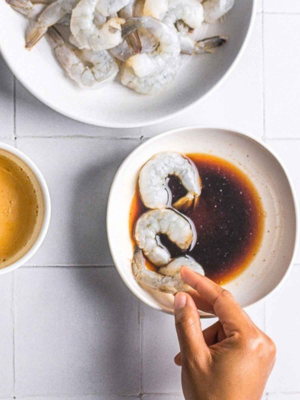 Dipping the shrimp into the soy sauce and brown sugar mix.