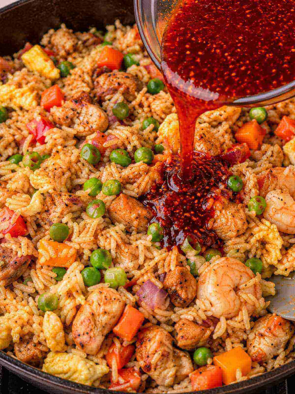 Adding the sauce into the rice with vegetables.
