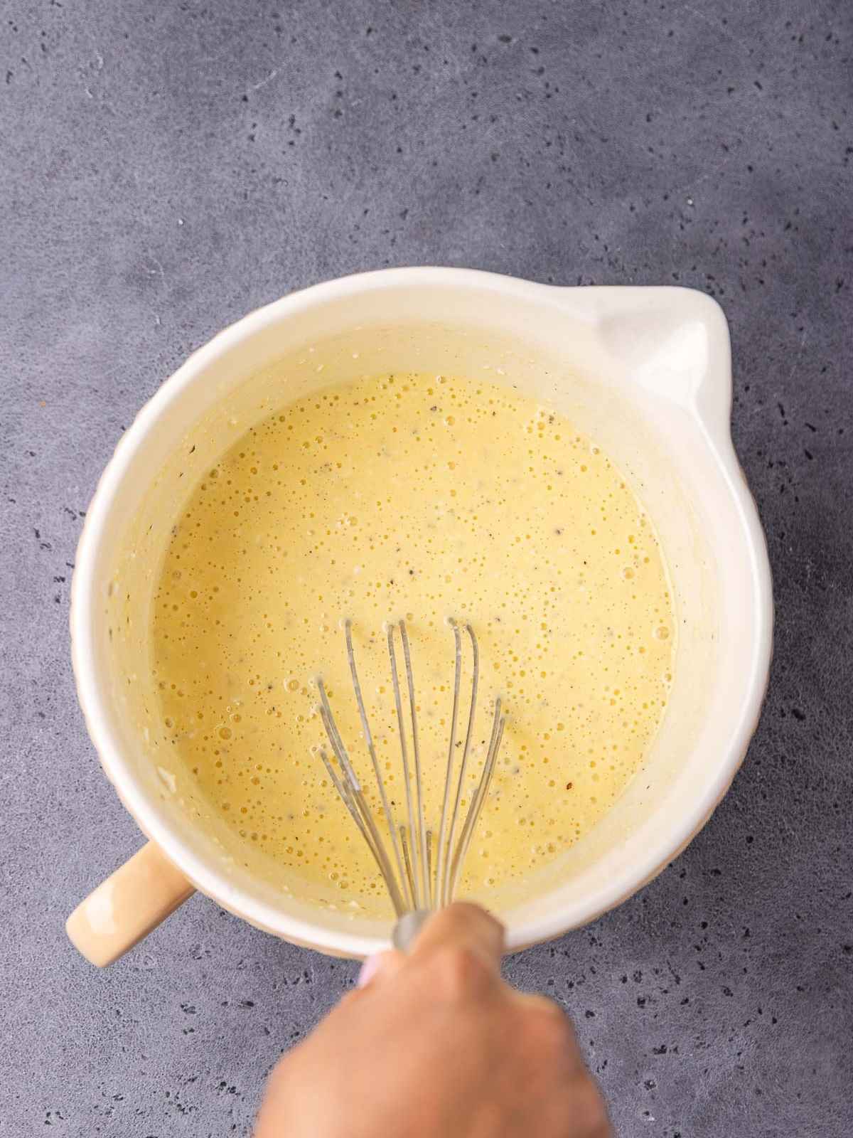 Mixing the cottage cheese, eggs, and seasonings.